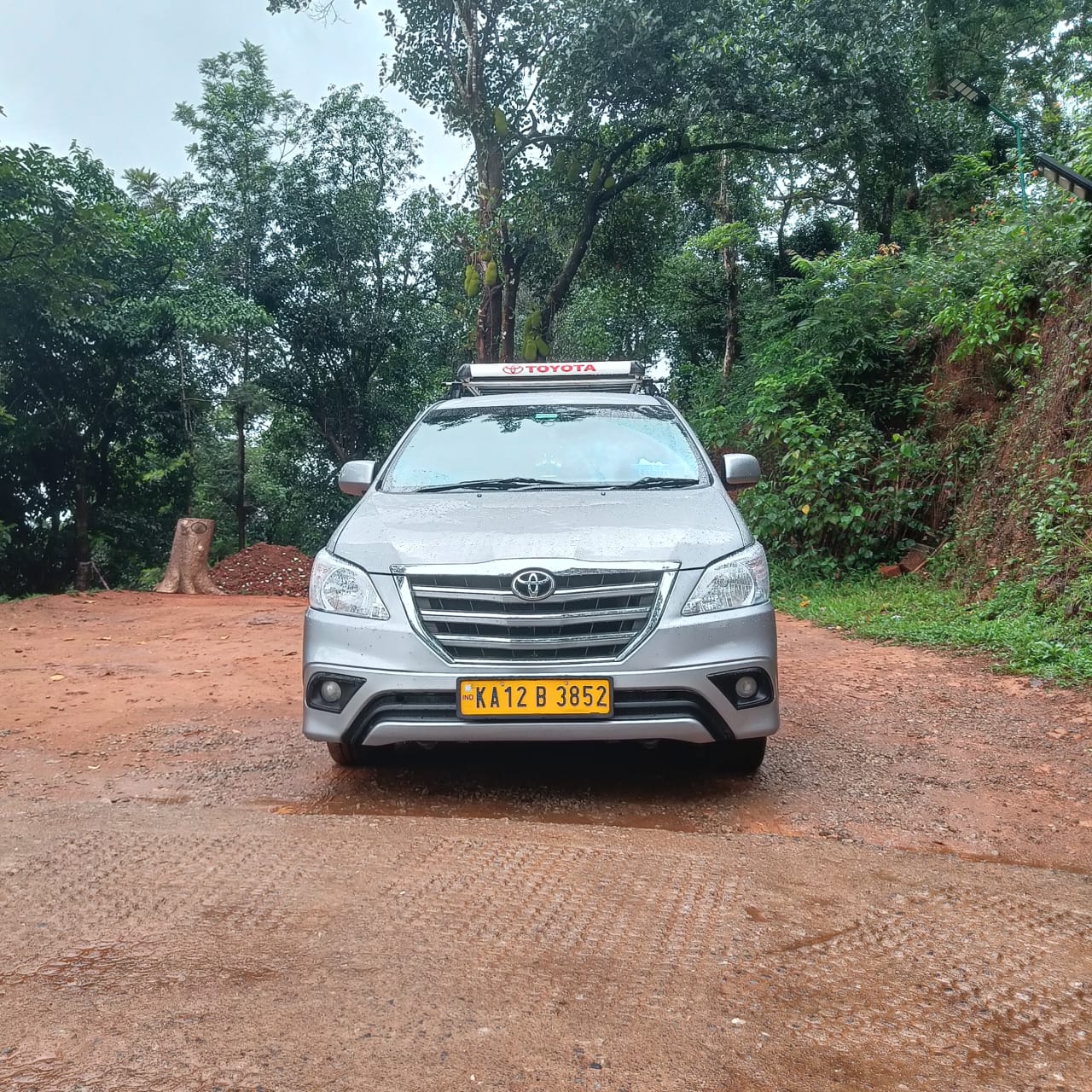 Innova taxi front view on a green Coorg hill road