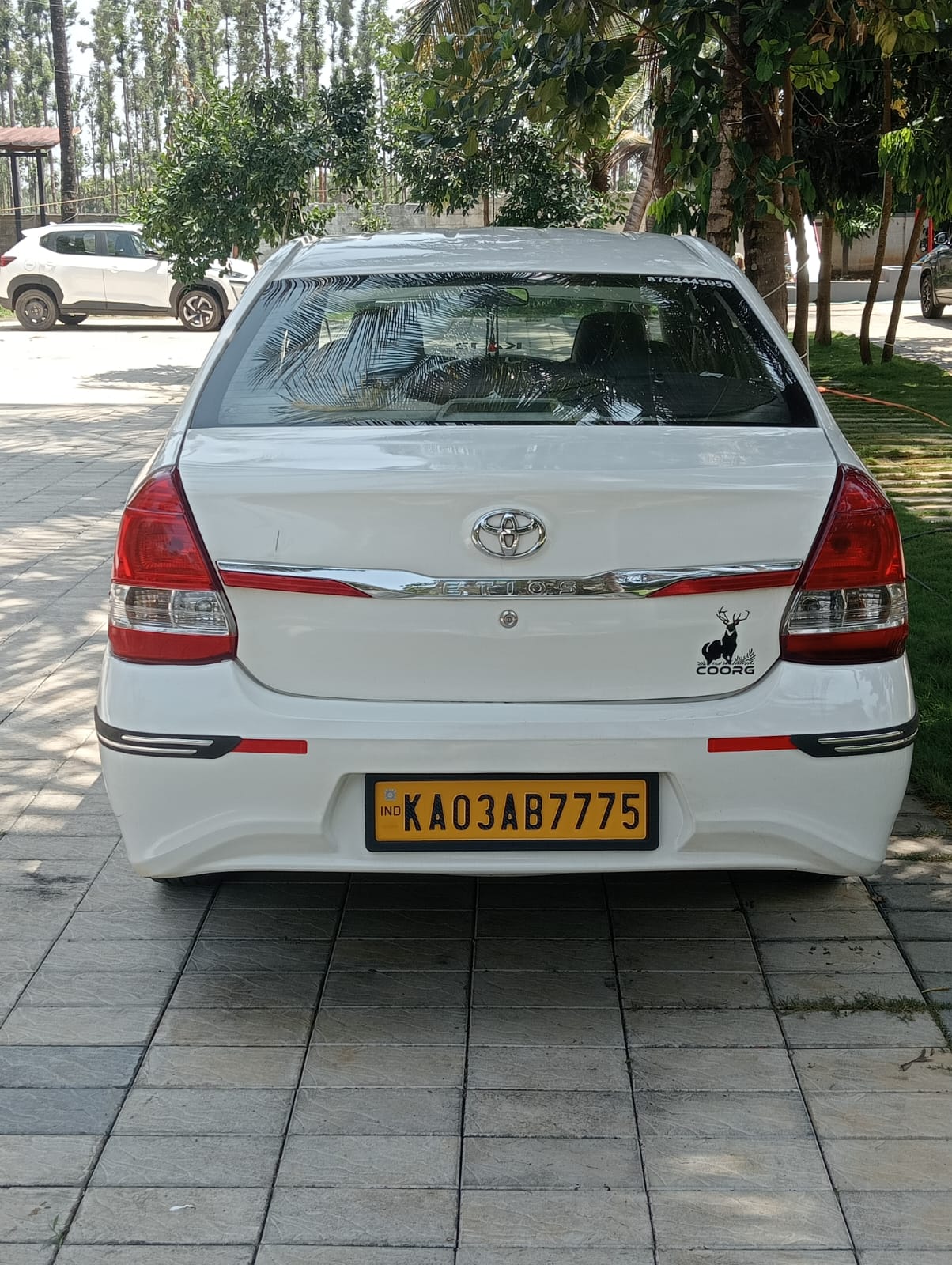 White sedan taxi rear view for Coorg local travel