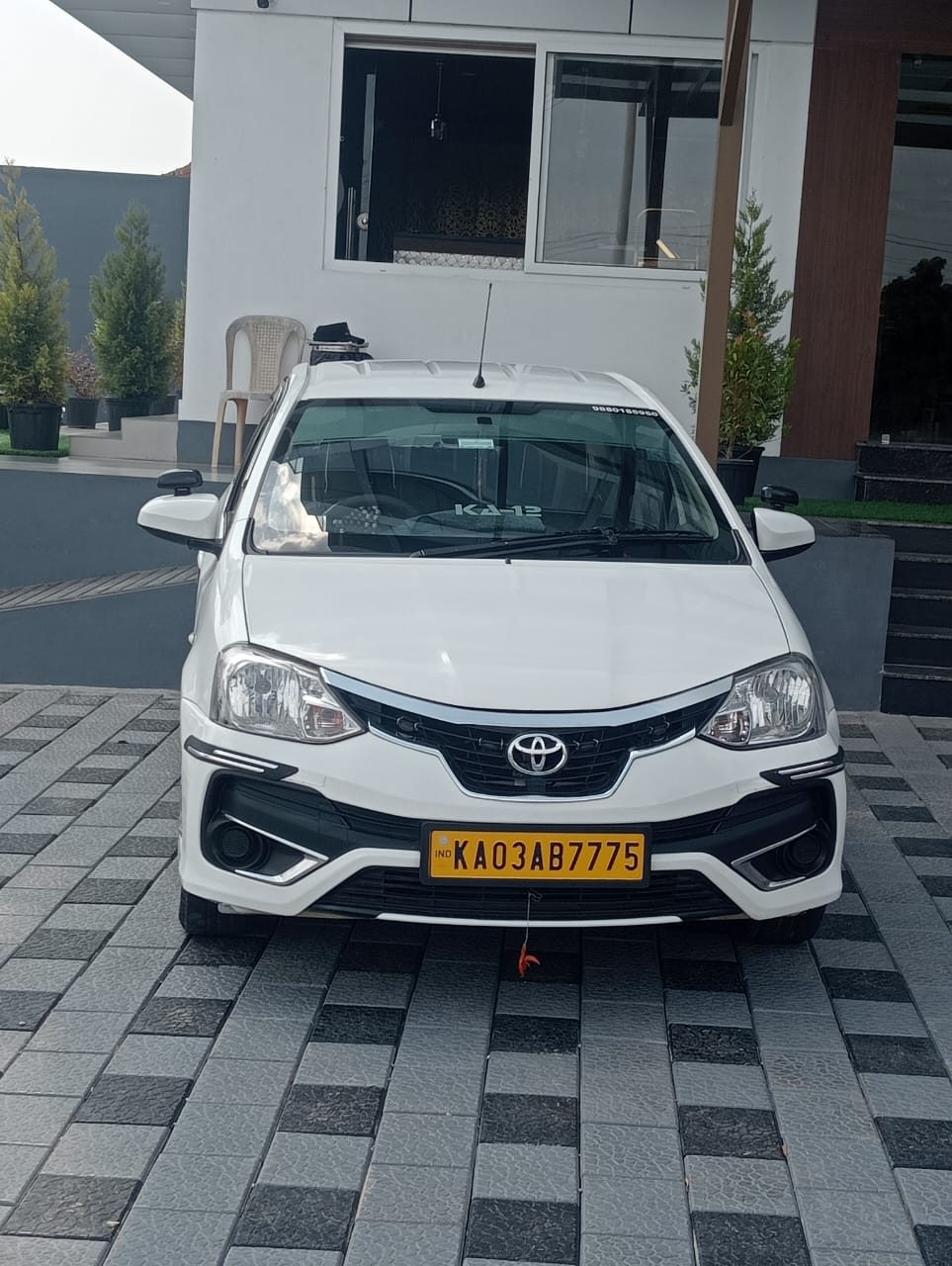 White hatchback taxi front view parked near a building